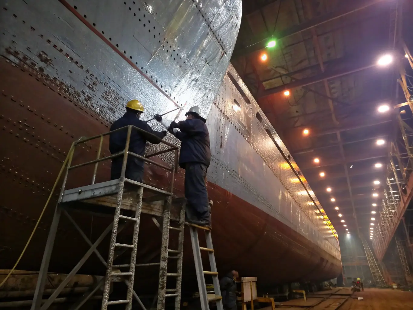 A detailed image of a boat hull undergoing maintenance, with workers applying protective coatings and repairing any damages, highlighting the care and attention to detail in hull maintenance.